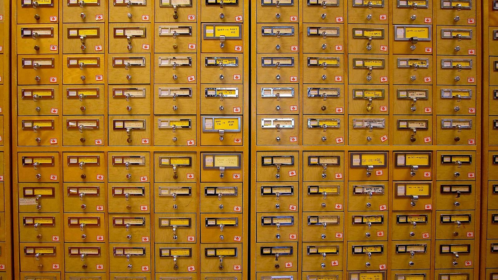 A wall of wooden card-catalogue drawers in a library
