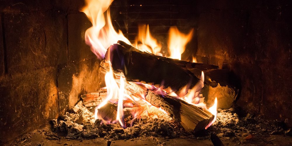 A wood fire burning low in a fireplace