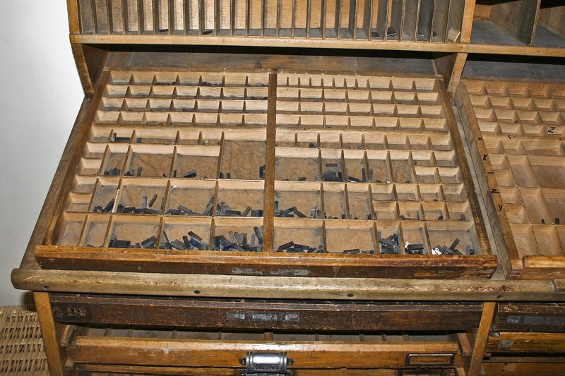 A printer's type case of small wooden compartments