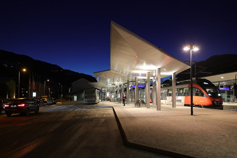 An empty railway platform under its canopy at night